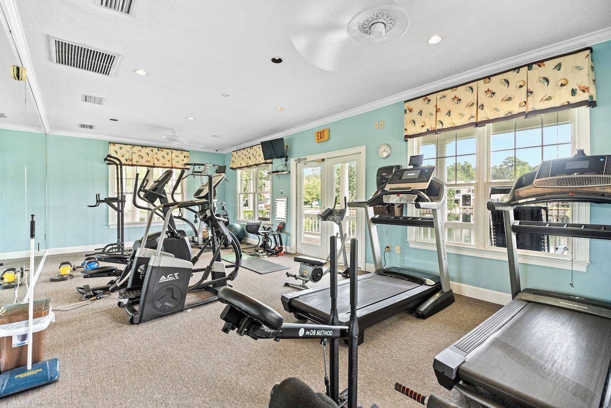 A gym with treadmills, elliptical machines, and weight equipment.