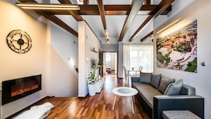 Een moderne woonkamer met een open haard, een bank, een salontafel en een groot schilderij aan de muur.