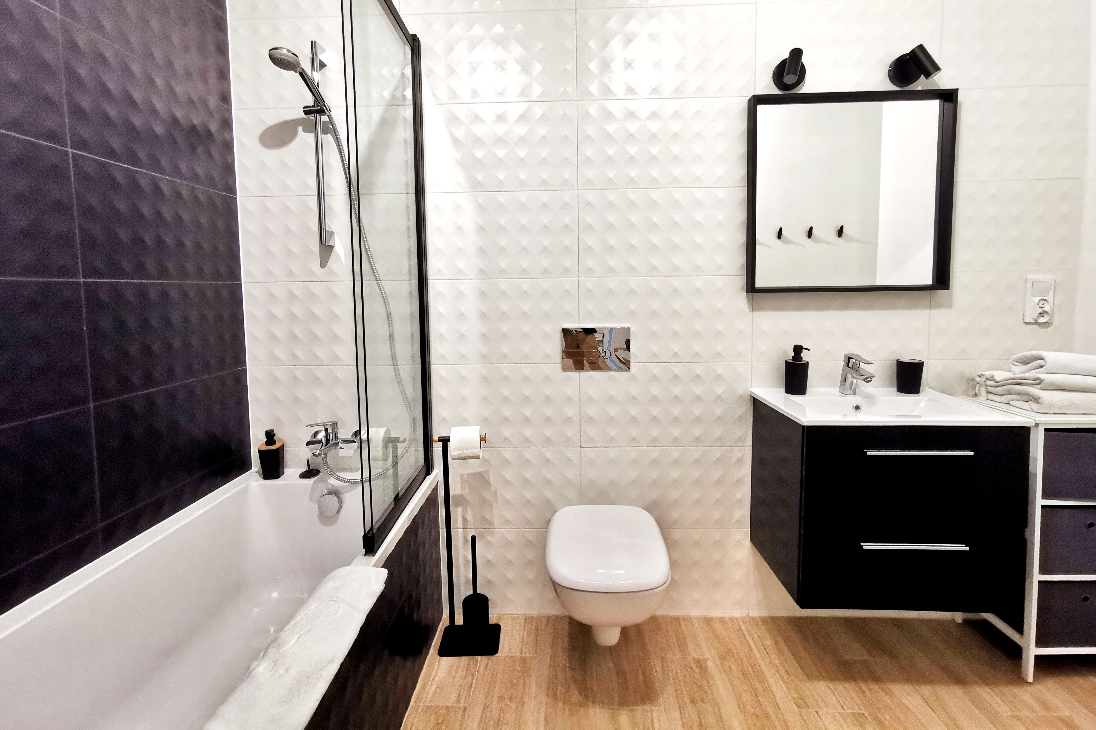 A modern bathroom with a bathtub, toilet, and vanity.