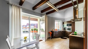 Een moderne keuken met een magnetron, oven en een houten kast.