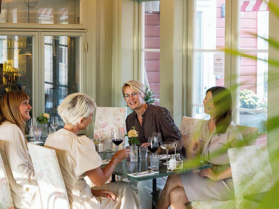 A dining area with a table set for four people, surrounded by chairs.