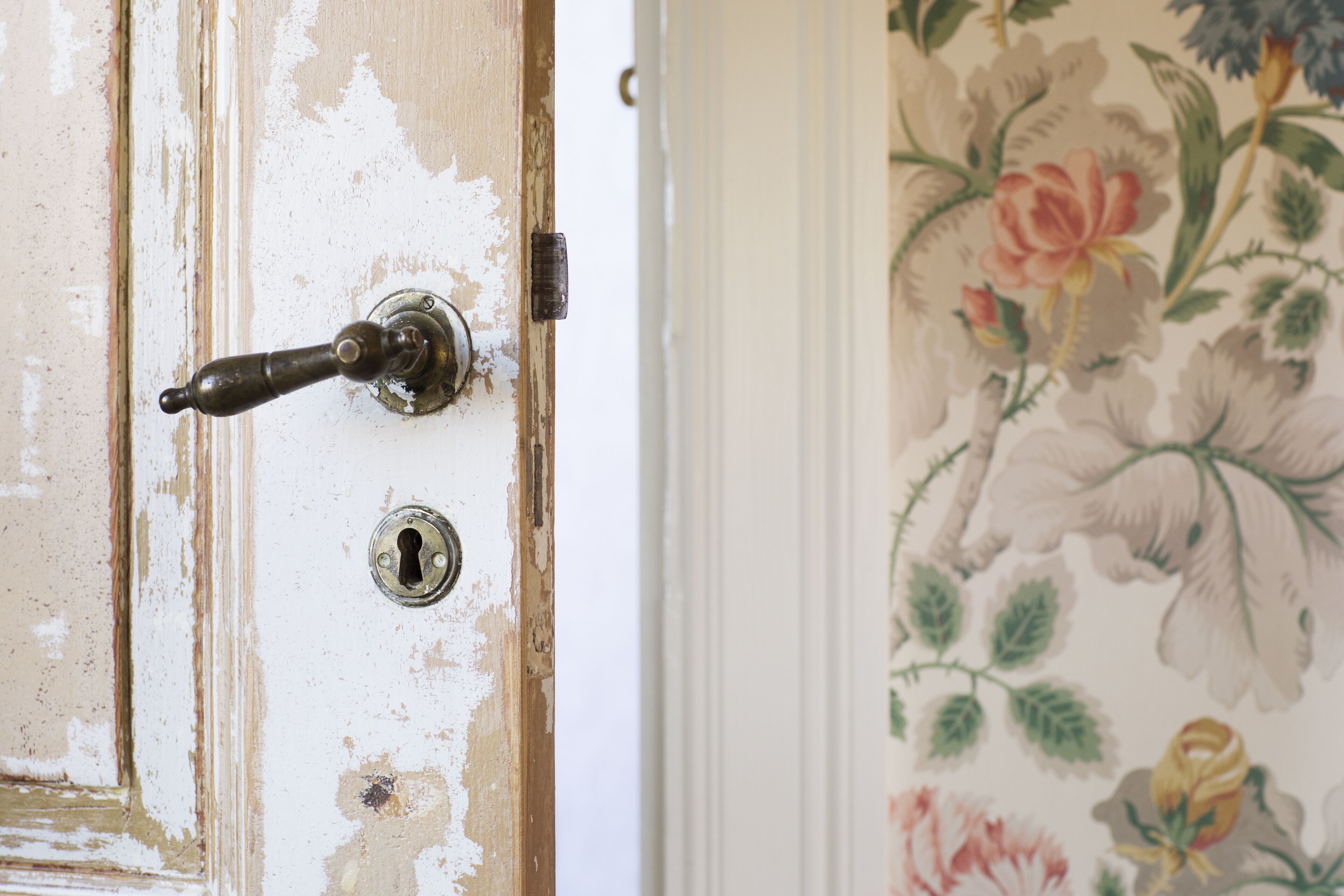 Une porte dont la peinture s’écaillait et un sonnette ancienne.