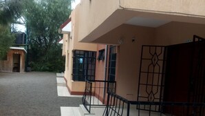 A building with a flat roof and a covered outdoor area with a metal railing.
