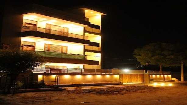 A multi-story building with balconies and a covered walkway.