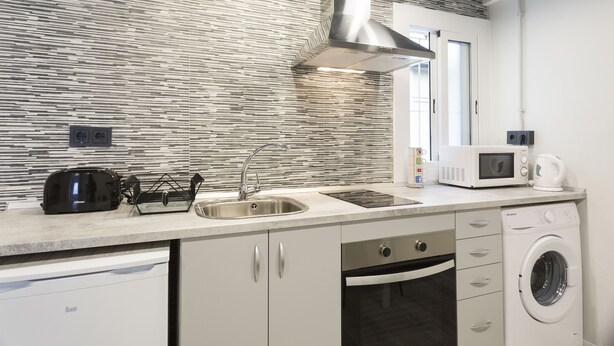 A modern kitchen with a stainless steel sink, a microwave, a toaster, and a built-in oven. - Stay U-nique Apartment Llobregat (L'Hospitalet de Llobregat)
