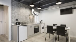 Una cocina moderna con lavavajillas, horno y microondas. Hay un comedor con mesa y sillas.