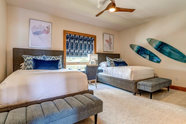 A bedroom with two beds, a window, a ceiling fan, and artwork on the walls. - The Resort at Kapalua Bay | Ocean View 3 BR | Car Incl. w/ 6+ Nights | MON-6401 by KBM (Lahaina)