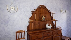 A wooden dresser with drawers and a mirror, a chair, and two wall sconces with light bulbs. - Arriola Txiki Apartment - Andutz (Deba)
