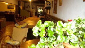 A cozy living room with a long wooden table, comfortable seating, and a potted plant. - Arriola Txiki Apartment - Andutz (Deba)