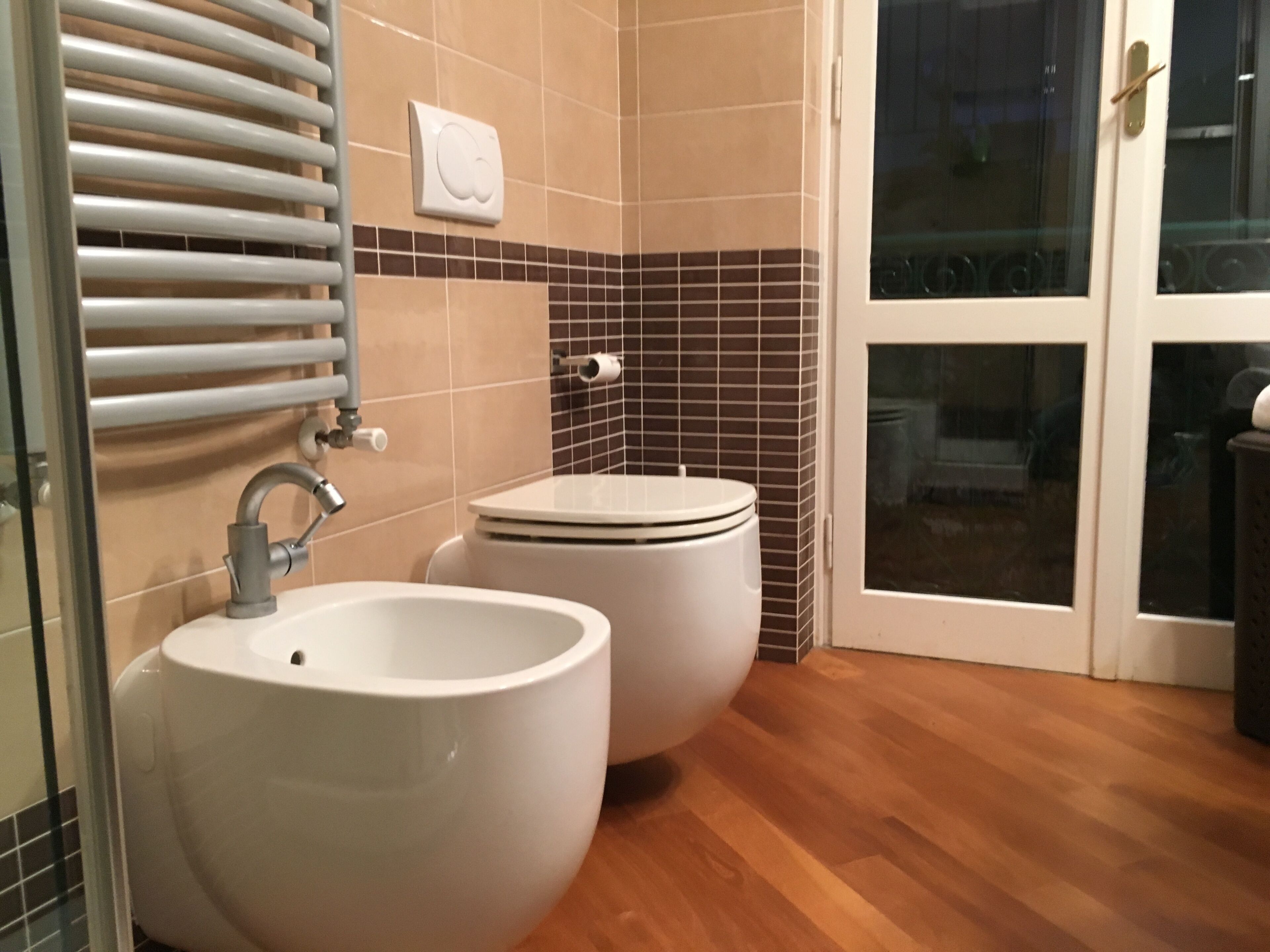 A bathroom with a sink, toilet, and a towel rack.
