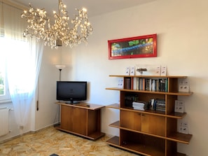 Relax in this stylish living room with a flat-screen TV, bookshelf, and framed artwork.