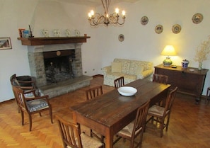 Un salón acogedor con chimenea, mesa de comedor de madera y asientos cómodos.