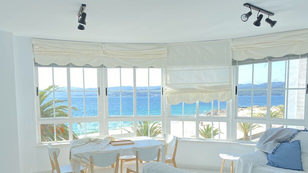 Habitación con vista al mar, que incluye una cama, una mesa y sillas.