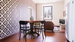 Un coin repas avec un mur décoré de motifs, une table ronde et quatre chaises.