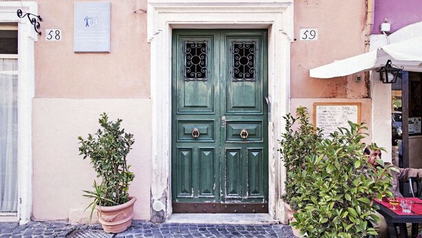 A green double door with a metal gate, flanked by potted plants, and numbered signs 58 and 59 on the building facade. - Garibaldi RTH (Rome)