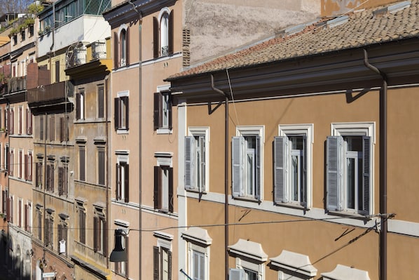 A row of multi-story buildings with uniform window designs and shutters. - Ripa RTH (Rome)