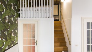 Una escalera con una puerta blanca y una barandilla de madera.