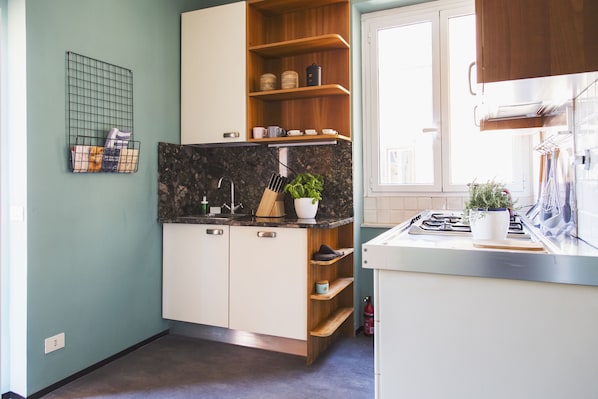 A modern kitchen with wooden cabinets, a granite countertop, and a window providing natural light.