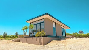 A modern building with large glass windows, a flat roof, and a concrete base. - Quinta Nicolás Valle de Guadalupe (Valle de Guadalupe)