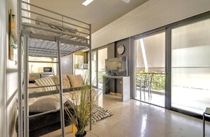 A modern interior with a bunk bed, a kitchen area, and large windows. - Impeccable 3-bed Apartment in Athens (Nea Ionia)