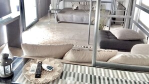 A bunk bed room with a sofa, a small table with a remote control, and a decorative item on the wall. - Impeccable 3-bed Apartment in Athens (Nea Ionia)