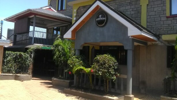 A two-story building with a prominent Guinness sign on the front. - Pafo Hotel (Kisumu)