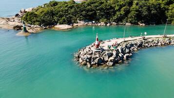 A rocky pier extending into turquoise waters, surrounded by lush greenery.