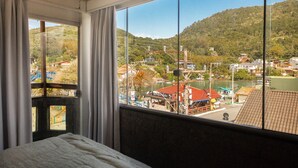 Una habitación con un ventanal grande que da a una ciudad y colinas.