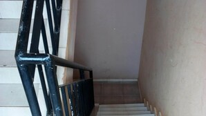 Una escalera con barandilla de metal negro y peldaños color beige.