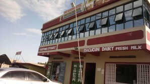 A two-story building with a sign for 'The Baron Motel, Bar & Restaurant' and 'RGA Thima Supermarket'. - The Baron Hotel (Thika)