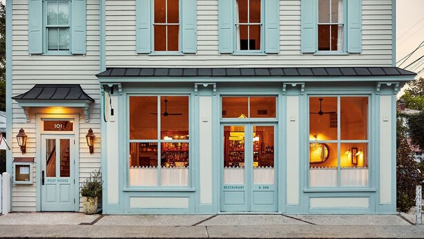 Un immeuble abritant une poste, un restaurant et un établissement proposant six services différents (hôtel, etc.).