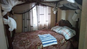 Une chambre à coucher avec un lit, des rideaux et un baldaquin.
