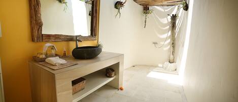 Une salle de bain avec un meuble-lavabo en bois, un grand miroir et un évier.