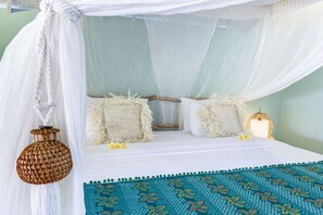 A bed with a canopy, two pillows, a woven lamp, and a patterned rug. - The Chillhouse Canggu (Canggu)