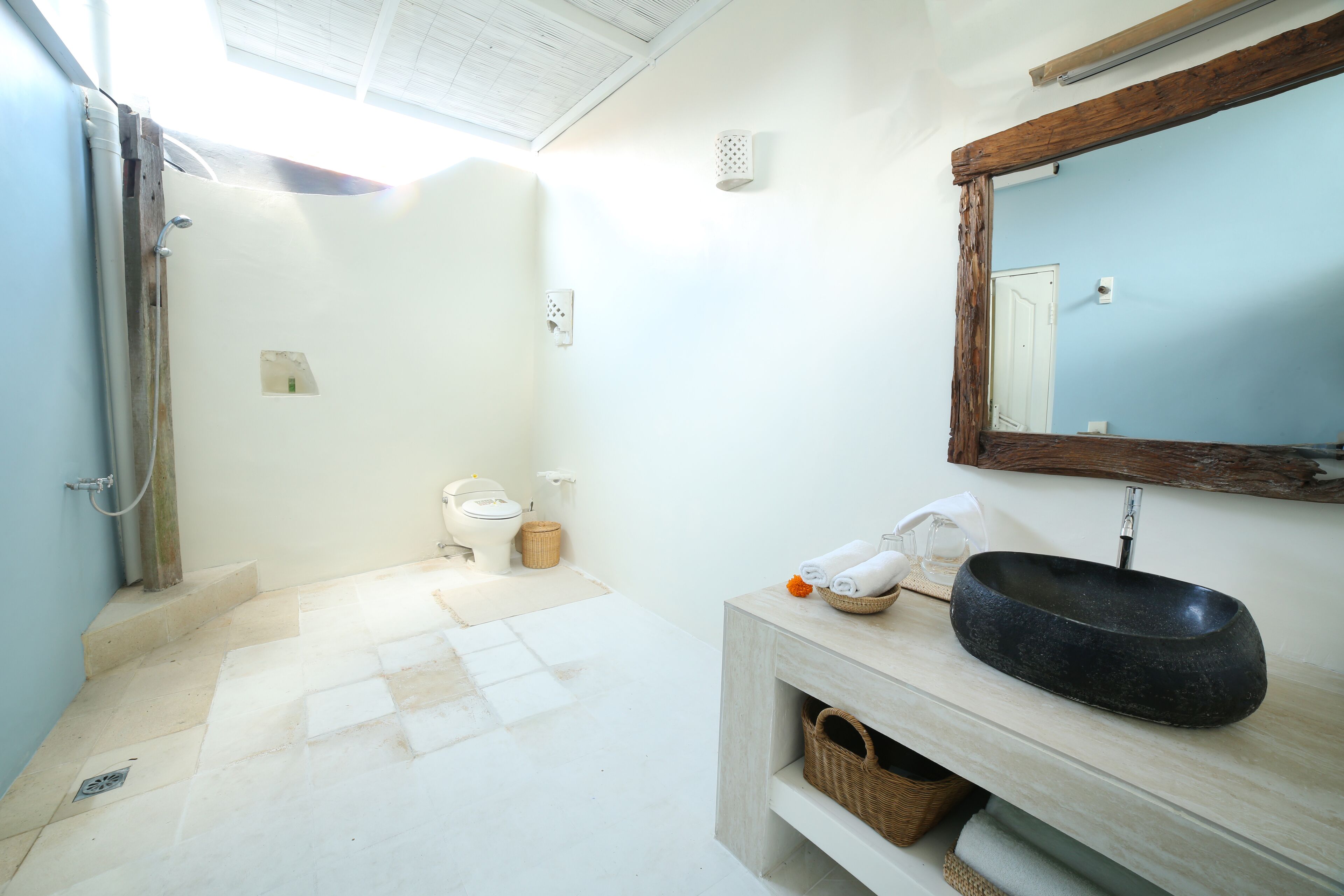 Une salle de bain équipée d’une douche, de toilettes, d’un lavabo et d’un miroir.