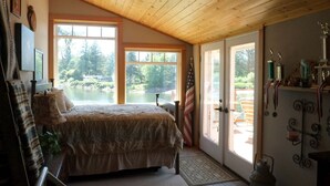 Une chambre avec un grand lit, une vue sur un lac et un drapeau américain.