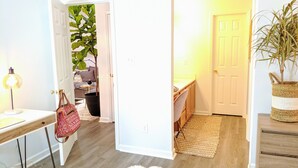 A hallway with a desk, a chair, a lamp, a plant, and a door leading to another room. - RARE⭐️DownTown Matthews ❤️Walk to Shops Restaurants Hiking❤️20 min to Charlotte (Matthews)