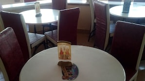 A round table with a poster and a small item on it. - Witas Lodge (Nakuru)