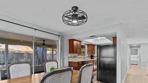 Una cocina moderna con comedor, ventanas amplias y vista al jardín trasero.