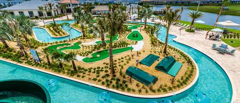 A resort pool area with multiple swimming pools, water slides, and lounge areas.