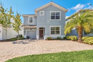 A two-story house with a garage, a well-maintained driveway, and a lawn. - Harry Potter • Lake View • Game Room • Private Pool & Spa • Near Disney (Kissimmee)