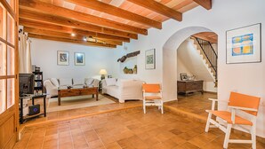 Amplia sala de estar con chimenea, un sofá, una mesa de centro y un mueble para la televisión.