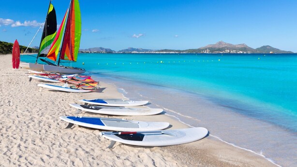 A beach with several windsurfing boards and a sailboat with colorful sails. - BARRETAS Ref. VP52 (Alcúdia)