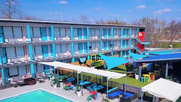 A hotel with a pool, outdoor seating, and a restaurant.