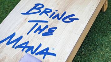 A wooden board with the text "Bring The Mania" and a small purple object on it.