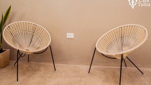 Two wicker chairs with black metal legs, positioned against a beige wall with a power outlet. - Premium Suite near Cathedral - 2 Min walk (Valladolid)