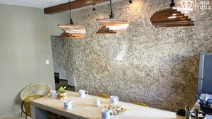 A kitchen with a stone wall, wooden pendant lights, a marble countertop, and wicker chairs. - Premium Suite near Cathedral - 2 Min walk (Valladolid)