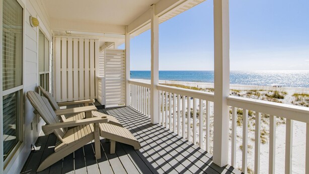 A covered porch with two Adirondack chairs, a view of the beach, and a clear blue sky. - Waterside (Both Sides of Heavenly Sunrise & Heavenly Sunset Combined)10 bedrooms (Orange Beach)