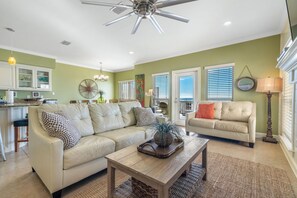 A spacious living room with a beige sofa, a wooden coffee table, and a ceiling fan. - Waterside (Both Sides of Heavenly Sunrise & Heavenly Sunset Combined)10 bedrooms (Orange Beach)