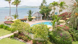 A poolside area with a gazebo, palm trees, and a view of the sea. - "ISLAND DREAMS" Spectacular Views, Pool, Beach, AC, Internet, 2 BR 2 Bath (Christiansted,)